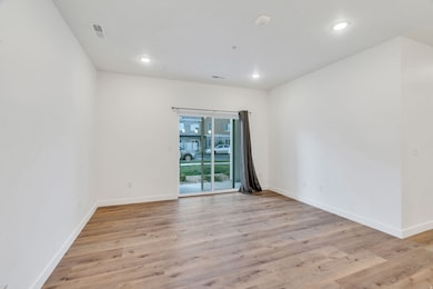 Empty room featuring light wood finished floors and recessed lighting
