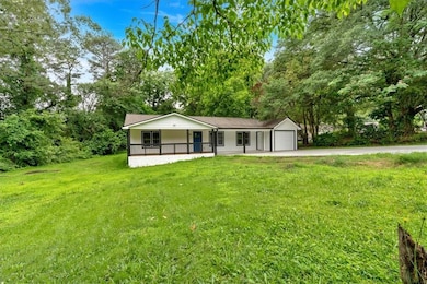 View of front of home featuring a porch, a front lawn, concrete driveway, and an attached garage