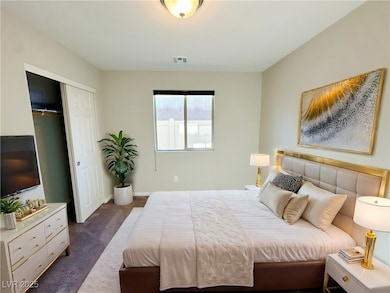 Bedroom featuring dark colored carpet, a closet, a