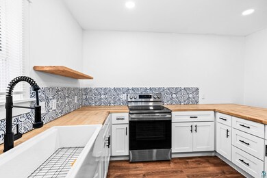 Kitchen featuring wooden counters, sink, stainless