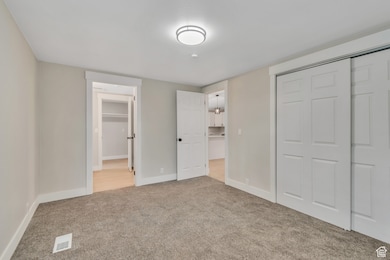Unfurnished bedroom featuring a closet and light carpet