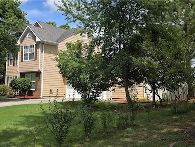 View of front of property featuring driveway, a front lawn, and roof with shingles