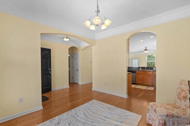 Living area featuring crown molding, arched walkwa