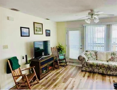 Living room with a ceiling fan and wood finished f