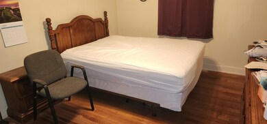 Bedroom featuring dark wood-type flooring and baseboards