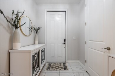 Foyer featuring light marble finish floors and bas