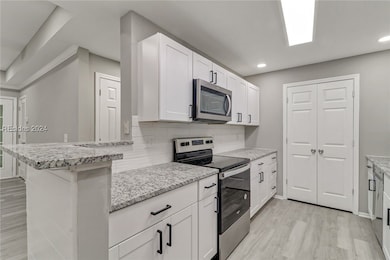 Kitchen with light stone countertops, appliances w