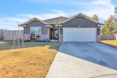 View of front of property featuring board and batten siding, concrete driveway, an attached garage, and brick siding