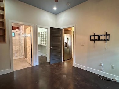 Unfurnished bedroom with concrete flooring, a spa
