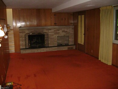 Paneled family room with wood burning fireplace.