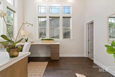 Office featuring dark wood-style floors and a towering ceiling