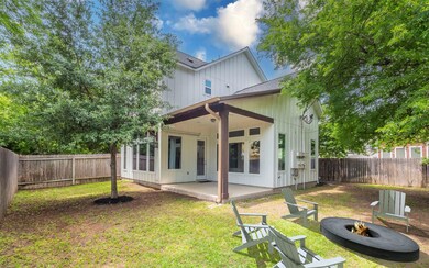 Back of property featuring a fire pit, board and 