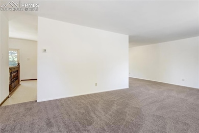 Spare room with light carpet and baseboards