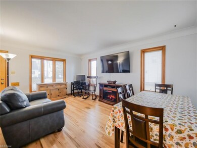 Living room featuring light hardwood / wood-style floors, a fireplace, and ornamental molding