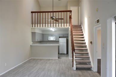 living room with dining & kitchen/breakfast bar beyond and upstairs study/loft/gameroom + primary bedroom suite