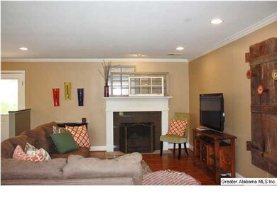 Living room features hardwood floors & a woodburni
