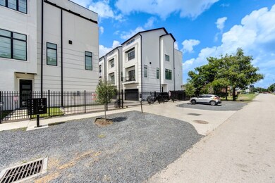 Modern residential area featuring contemporary white townhomes with black accents and large windows.