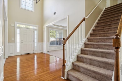 Foyer entrance featuring stairs, light wood-style 