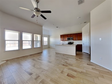 Unfurnished living room with wood finish floors and a ceiling fan