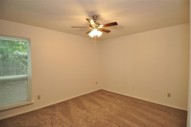 Spare room featuring carpet and a ceiling fan