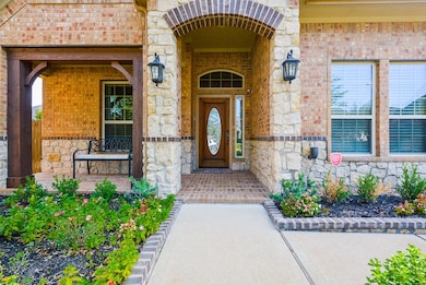The exquisite brick and stone front elevation with covered front porch provides a warm welcome to guests