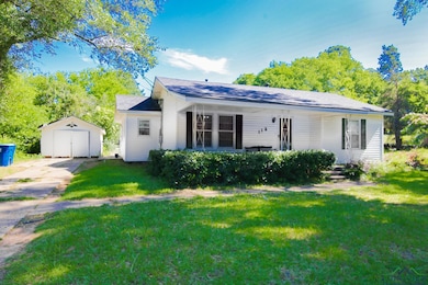 View of front of house with a front yard, a garage, and driveway