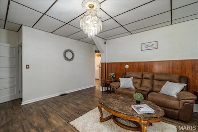 Main floor Living room featuring a chandelier, dark wood finished floors, and a drop ceiling