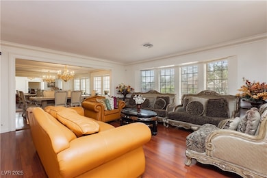 Living area with crown molding, a chandelier, heal
