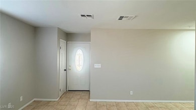 Foyer entrance with light tile patterned floors and baseboards
