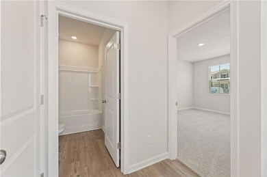 Corridor featuring light wood-style flooring, baseboards, and recessed lighting