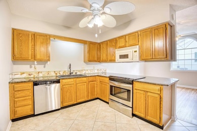 Kitchen featuring dark countertops, brown cabinetr