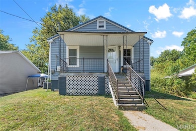 Bungalow-style home featuring covered porch, a front lawn, and stairs