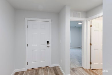 Foyer entrance with light wood-style floors and baseboards