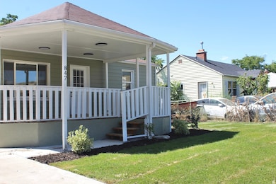View of property exterior featuring a lawn and a porch