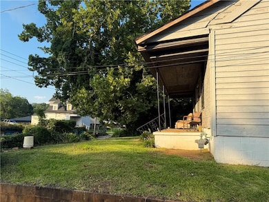 View of green lawn featuring covered porch