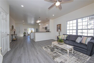 Hardwood floored living room featuring ceiling fan