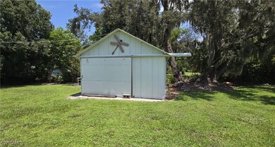 View of outdoor structure featuring a lawn