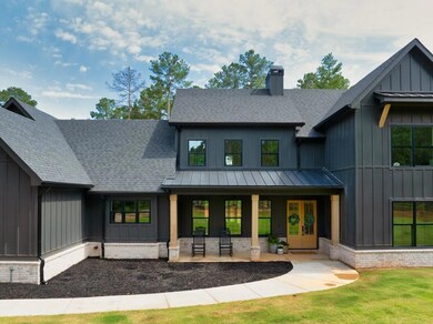 Modern farmhouse style home featuring a shingled roof, board and batten siding, and a chimney