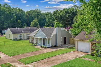 View of front facade with driveway, a garage, a shingled roof, a chimney, and a porch