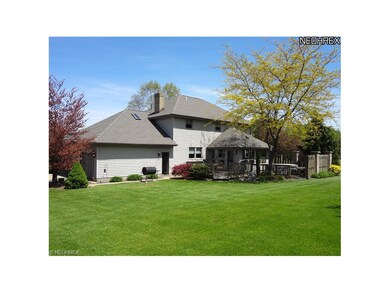 Back view, large wooden deck with hot tub.