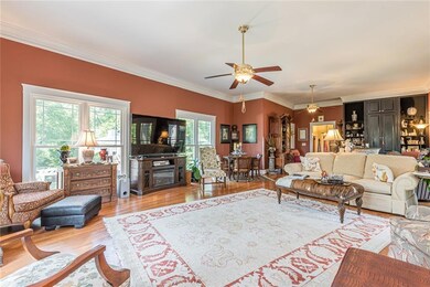 Living room with ornamental molding, light wood fi
