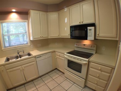 Kitchen with a sink, white appliances, light tile