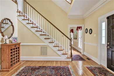 Foyer with front steps and hardwood floors. Second