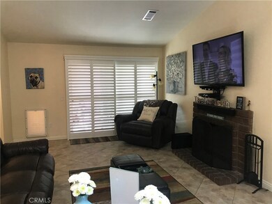 Living room with wood/gas burning fireplace.  Take note of the beautiful plantation style custom window coverings.  Open slider to very nice patio area.
