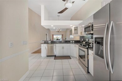 Kitchen featuring stainless steel appliances, dark countertops, ceiling fan, a peninsula, and white cabinets