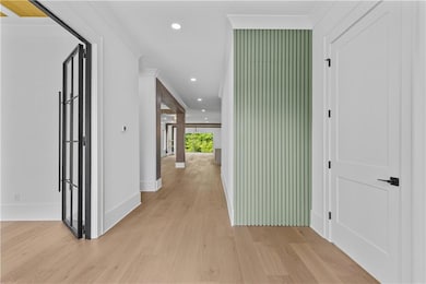 Hall with light wood-type flooring, recessed lighting, baseboards, and ornamental molding