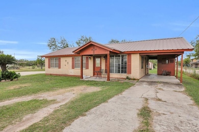 Ranch-style house with concrete driveway, a metal roof, and a porch