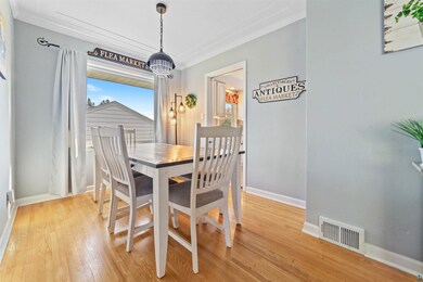 Dining space featuring hardwood flooring and crown