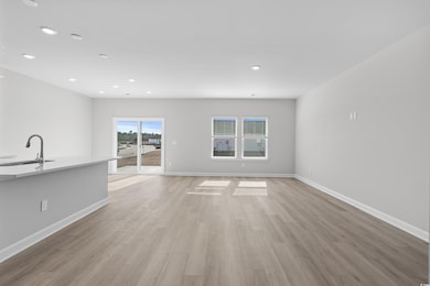 Unfurnished living room with sink and light hardwo