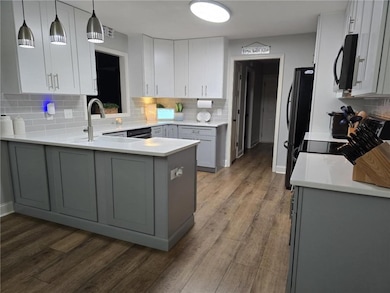 Kitchen with black microwave, decorative backsplas